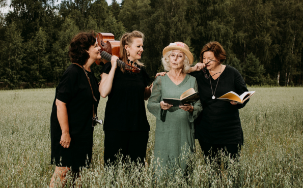 Neljä naista seisomassa pellolla. 